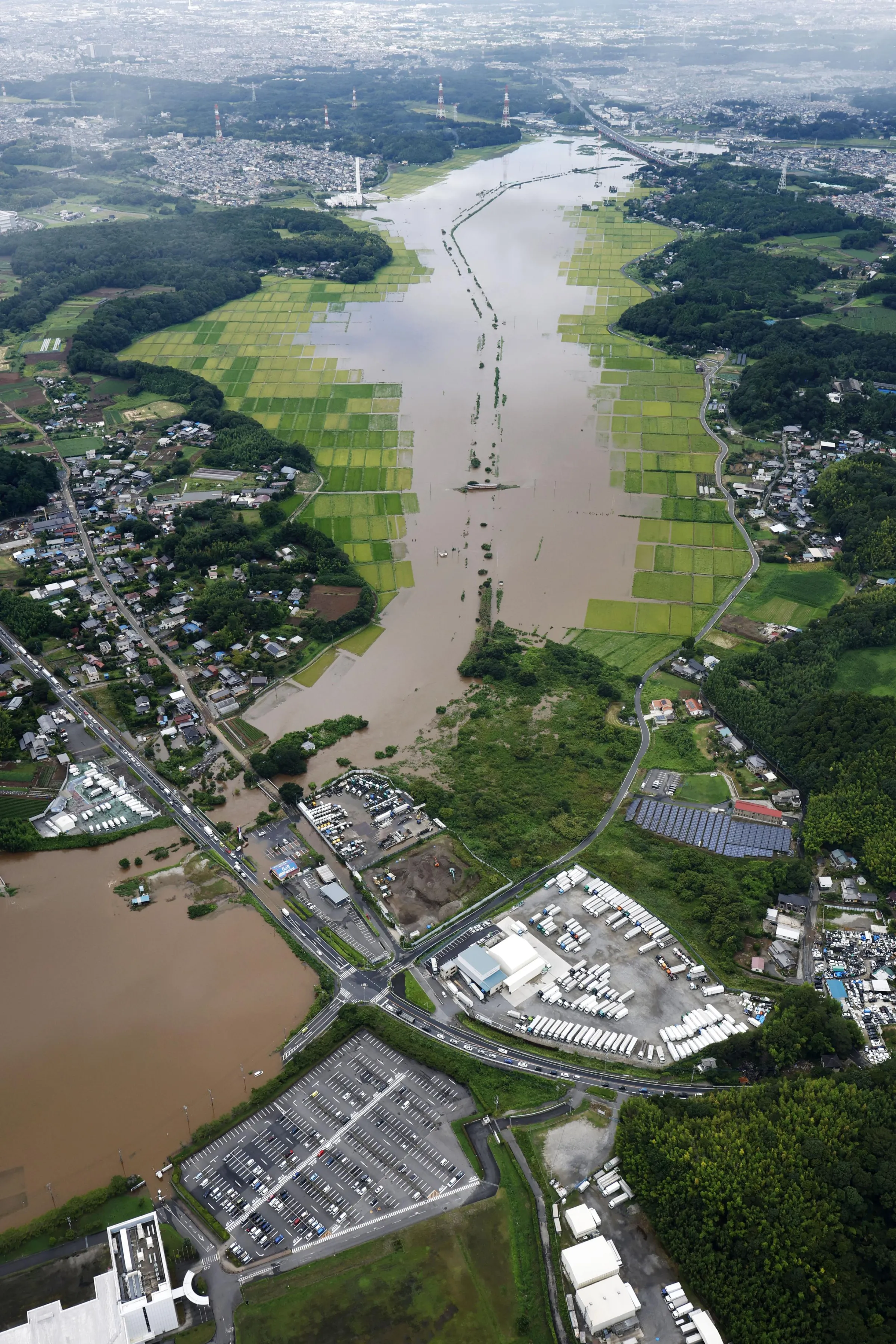 In this aerial photo, floodwaters inundate an area in Sakura, Chiba prefecture, Japan, Friday, Aug. 14, 2026. (Kota Endo/Kyodo News via AP)
