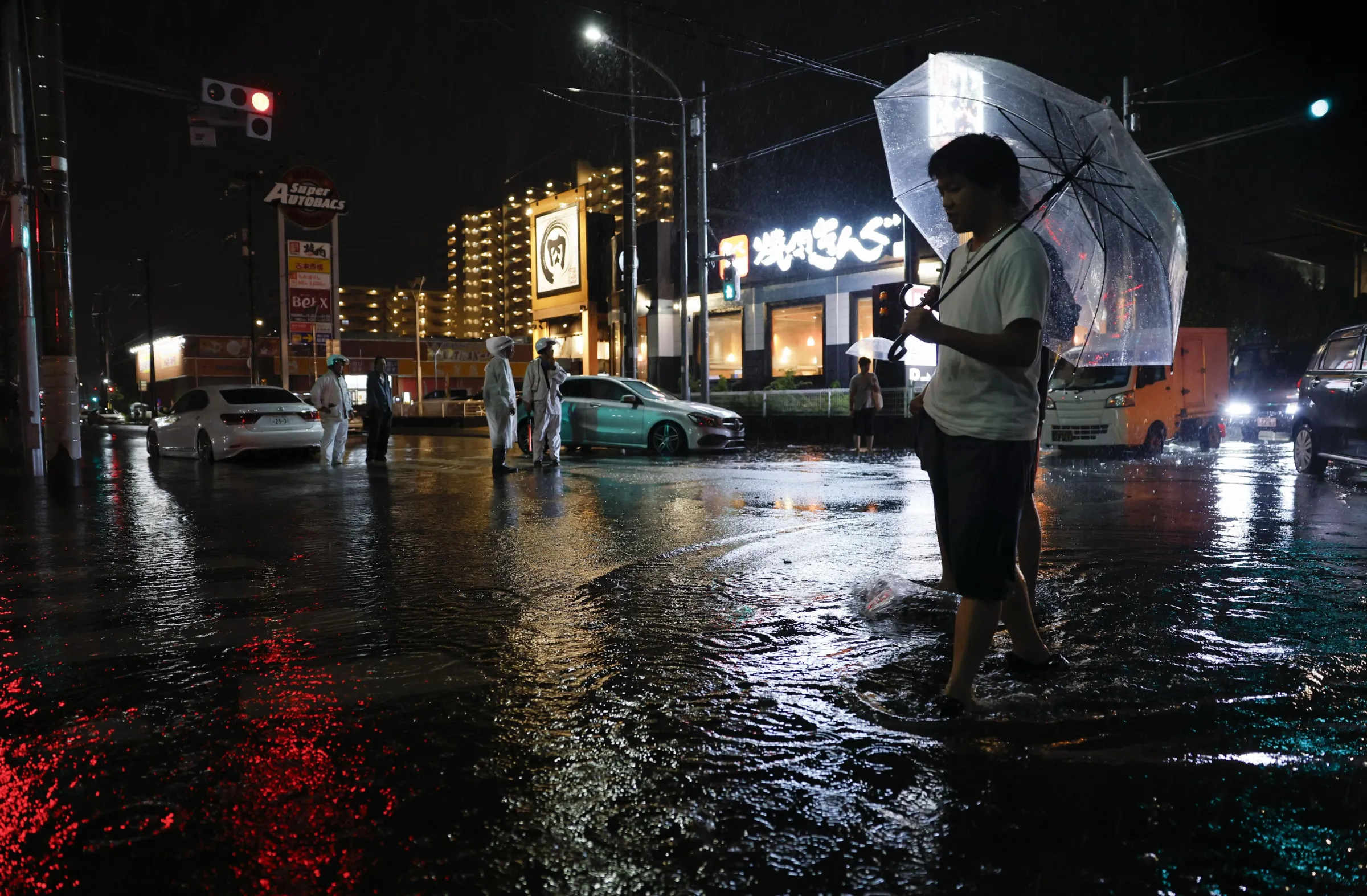 Torrential rain floods a road, causing a car to stall, in Ichikawa, Chiba prefecture, Japan, on Thursday, Aug. 13, 2026. (Kenzaburo Fukuhara/Kyodo News via AP)