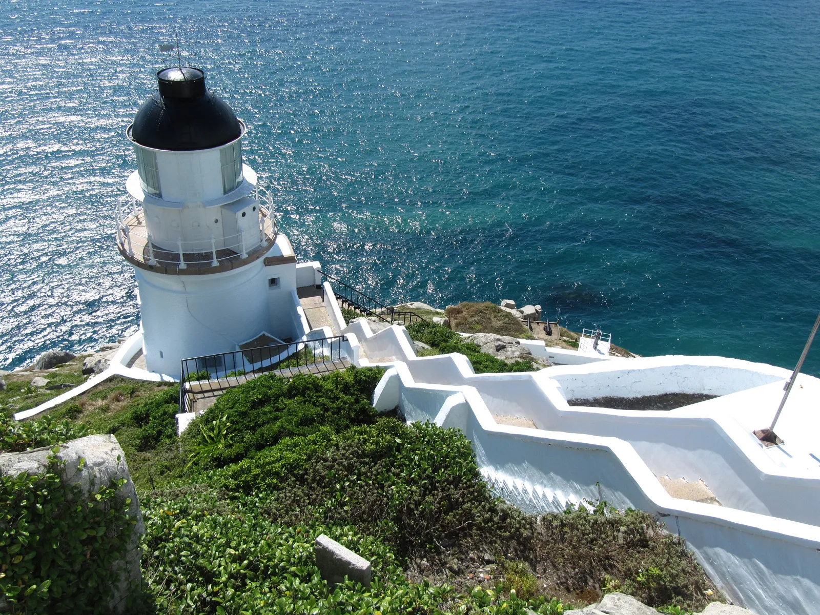 東引島燈塔矗立於海岸峭壁,黑色燈頂、白色塔身與湛藍海景,構成島上最具代表性的風景。(圖/連江縣政府提供)