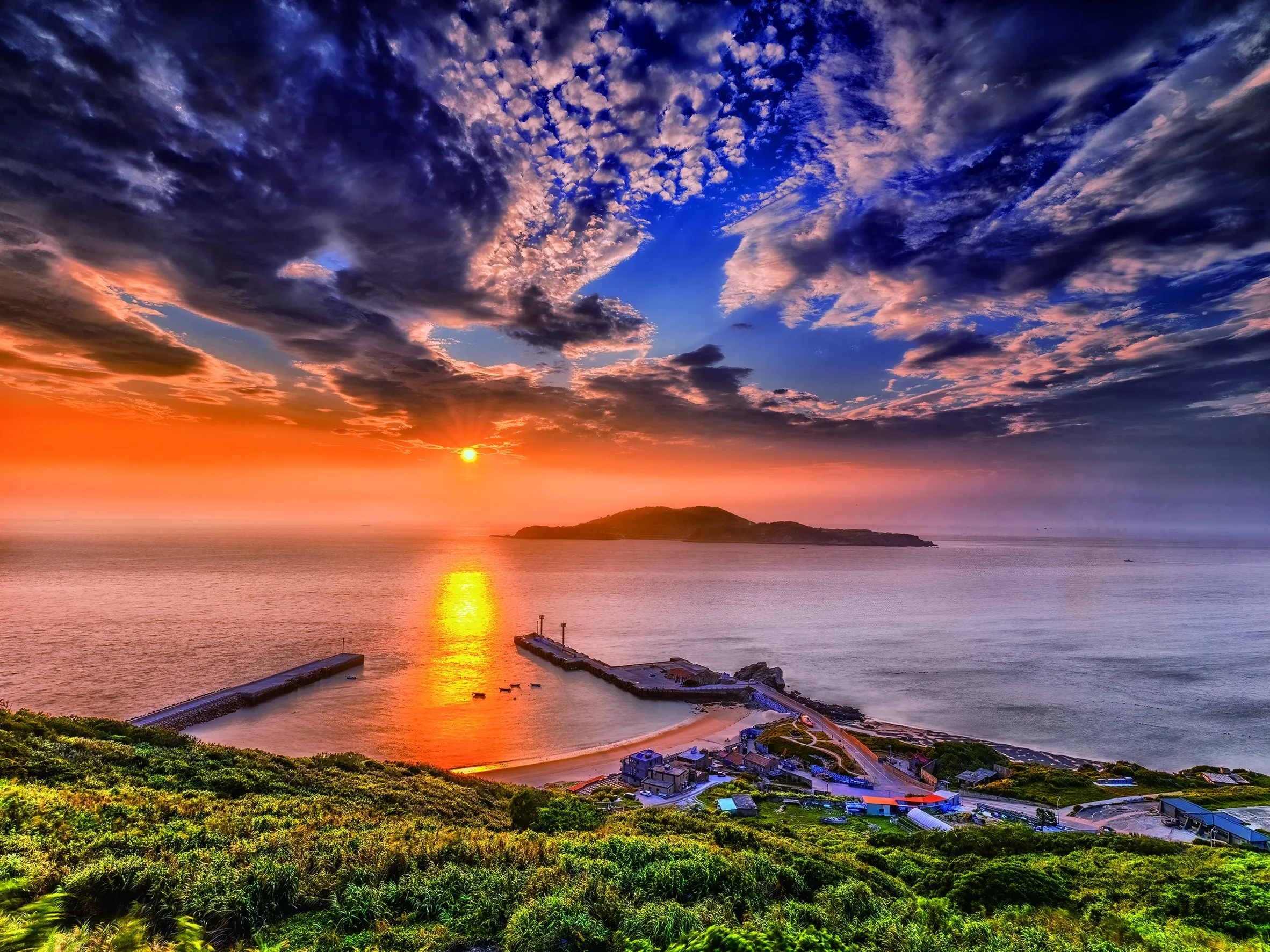 馬祖海岸夕陽將天空與海面染成金黃橘紅,是秋季跳島旅行不能錯過的浪漫時刻。(圖/連江縣政府提供)