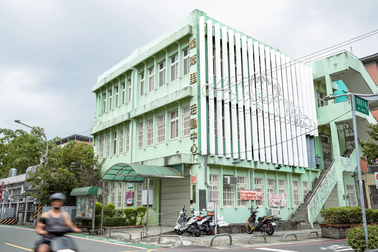 市民活動中心外牆的鍾老肖像,陪著龍潭人每日往來。(攝影/吳宙棋)