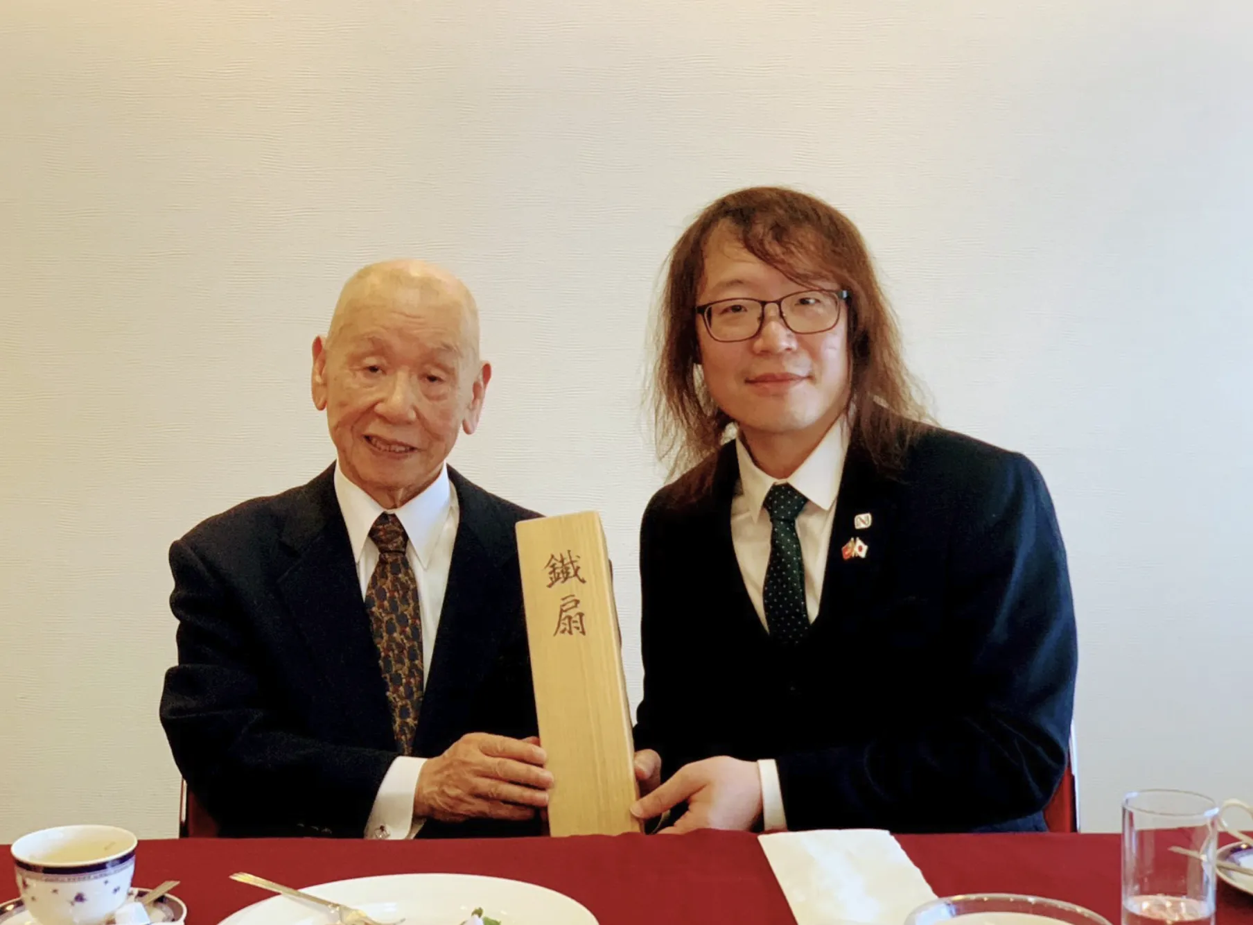 河端照孝(左)將這把玉鋼鐵扇贈予日本刀文化振興協會臺灣辦事處處長黃朝鍵(右),見證文化情誼跨海傳承(圖/河端照孝贈送鐵扇給黃朝鍵|《京都散策》策展團隊提供)