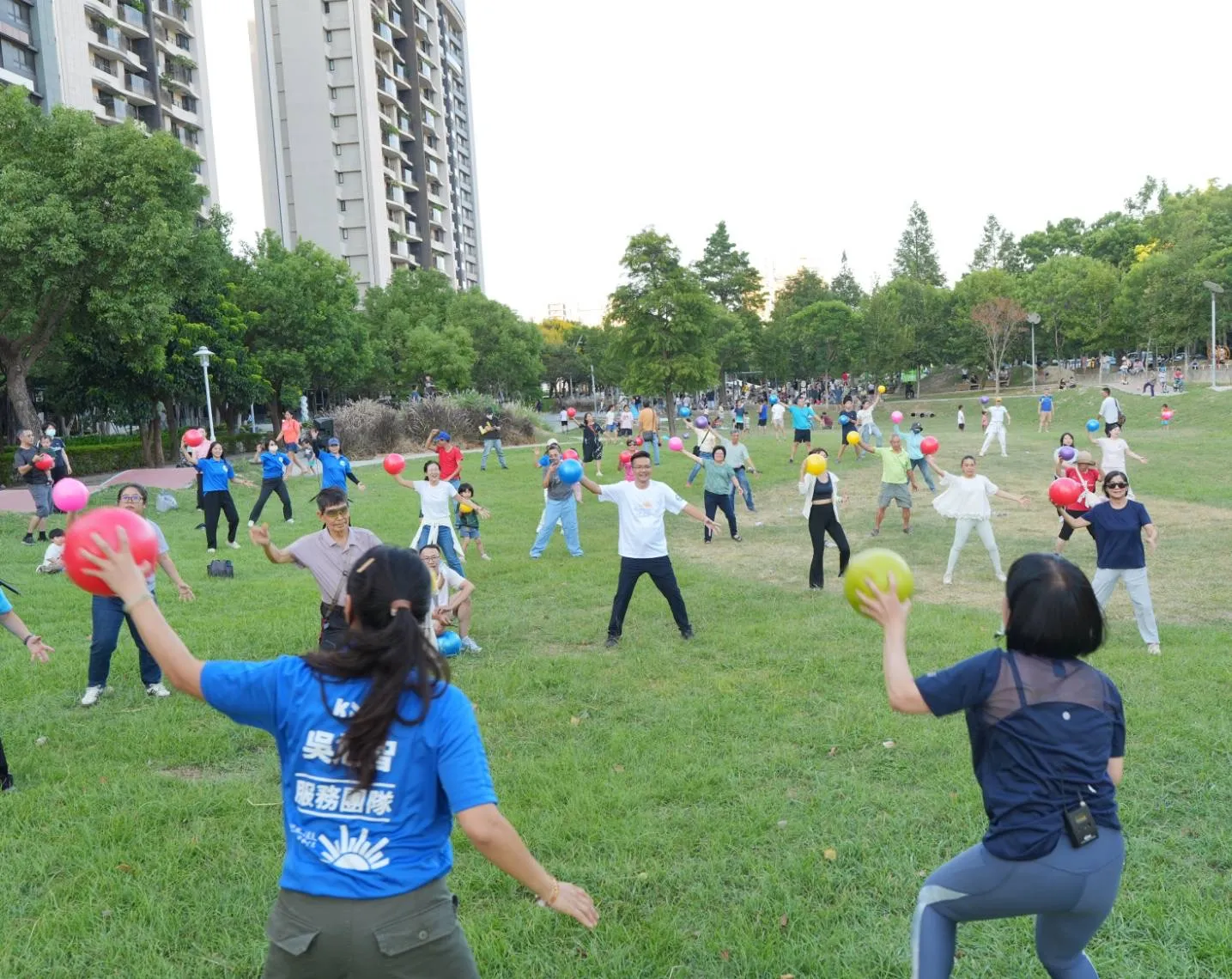 大批民眾在興隆公園草地跟著老師進行彈力球運動,親子與長輩共同參與,呈現全齡運動的活動訴求。(圖/吳旭智服務團隊提供)