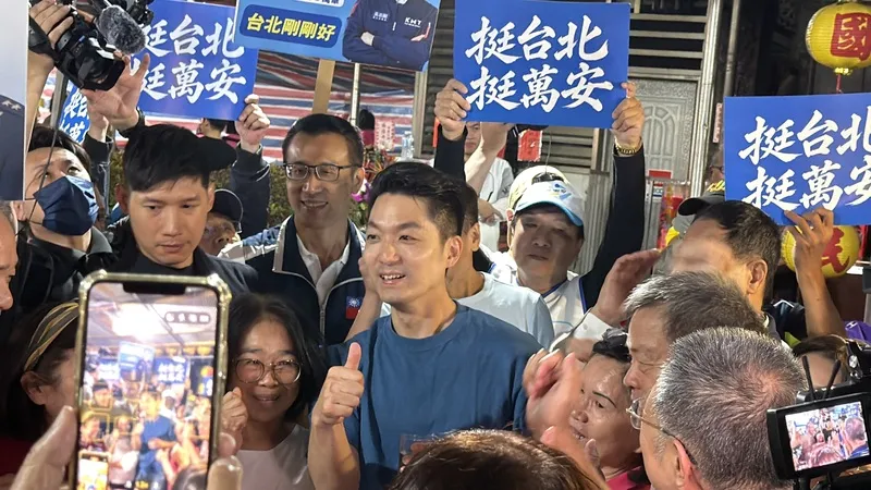 2026年10月14日,蔣萬安出席艋舺龍津宮匾額揭牌典禮,與支持者合照互動。(中央社)