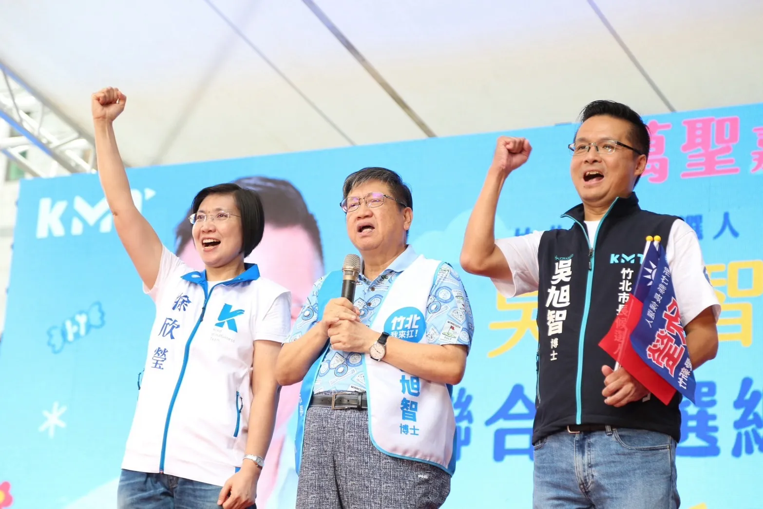 徐欣瑩左、吳旭智右與到場人士同台,兩名候選人舉拳呼應現場,爭取鄉親支持。(圖/吳旭智競選總部提供)