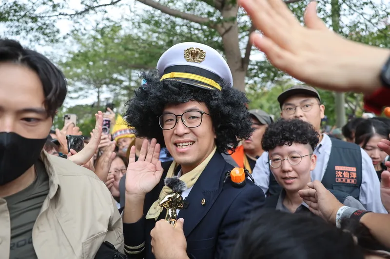 沈伯洋變裝參加萬聖節活動(3) 民進黨台北市長參選人沈伯洋(中)26日在台北市立天母棒球場出席「天母搞什麼鬼」萬聖節活動,沿途揮手向民眾致意。中央社記者王飛華攝115年10月26日