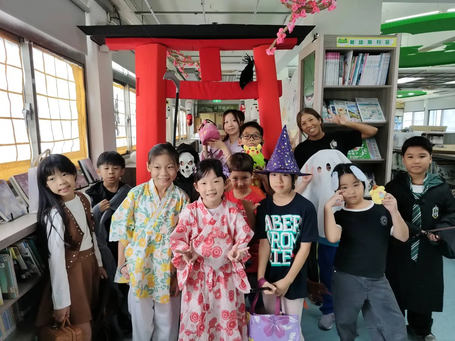 孩子以不同造型在紅色鳥居前合影,讓閱讀活動增添萬聖節氣氛。(圖/雨聲國小提供)