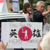 2025年7月26日、クーパーズタウンでの野球殿堂伝説の人物パレードで、鈴木一朗と妻の鈴木弓子さんがファンに手を振っている。(AP通信) 2025年7月26日、クーパーズタウンでの野球殿堂伝説の人物パレードで、鈴木一朗と妻の鈴木弓子さんがファンに手を振っている。(AP通信)